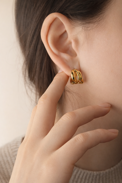 Woman wearing LUMHARA 18K gold plated hoop earrings, close up view