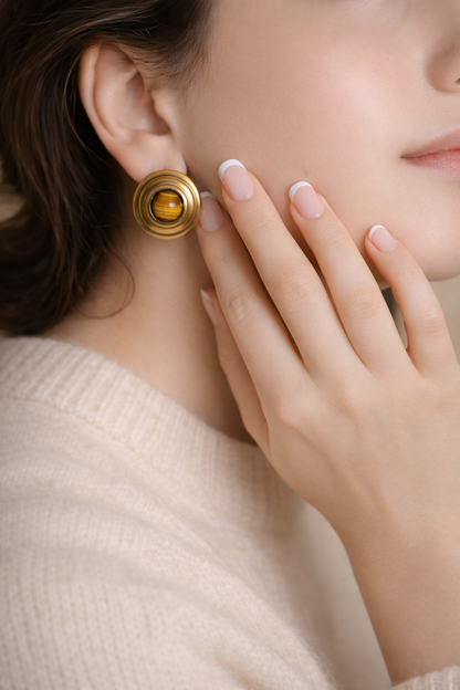 Woman wearing LUMHARA 18K gold plated earring with natural stone, soft sweater, elegant style
