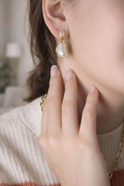Woman wearing LUMHARA 18K gold plated earring with natural stone in cozy indoor setting
