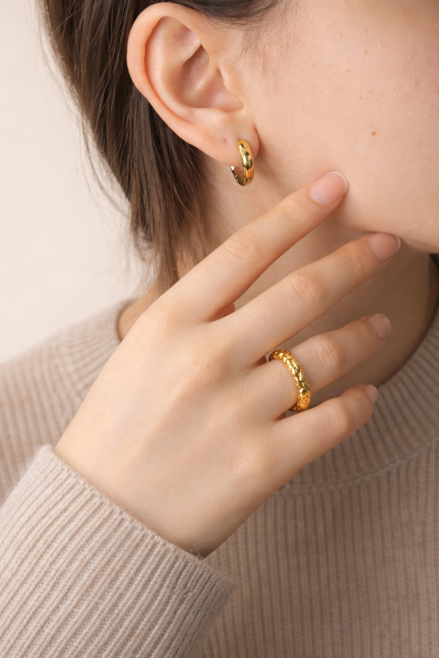 Woman wearing LUMHARA 18K gold plated earring and ring, close-up on hand and ear