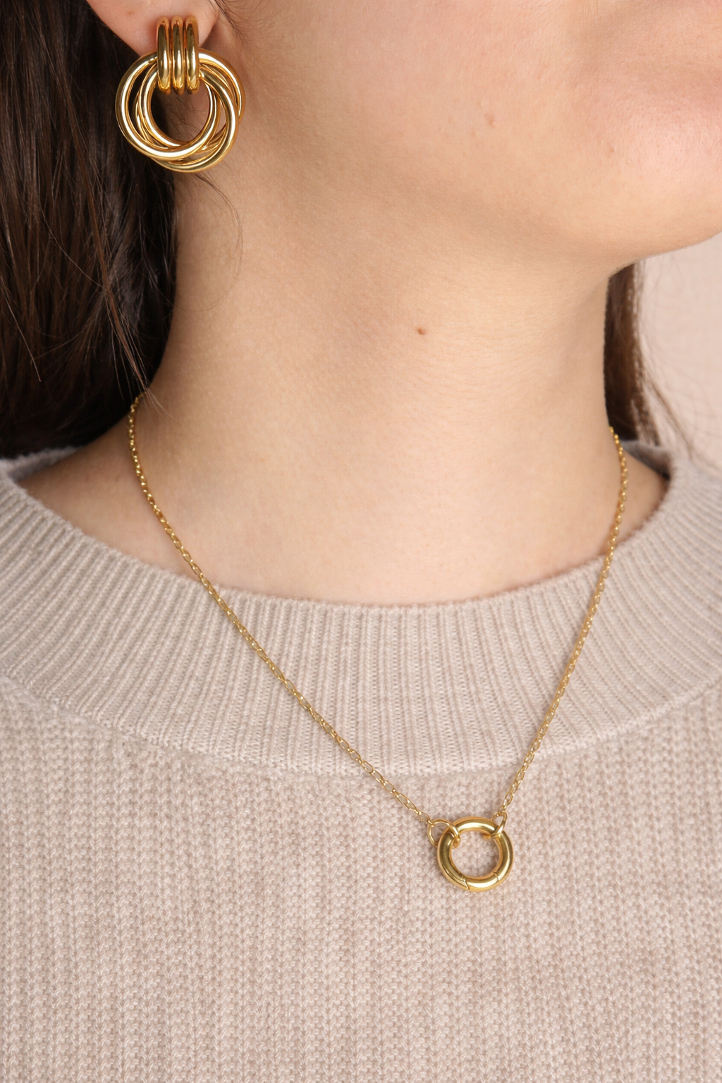 Woman wearing LUMHARA 18K gold plated circle earrings and necklace over beige sweater